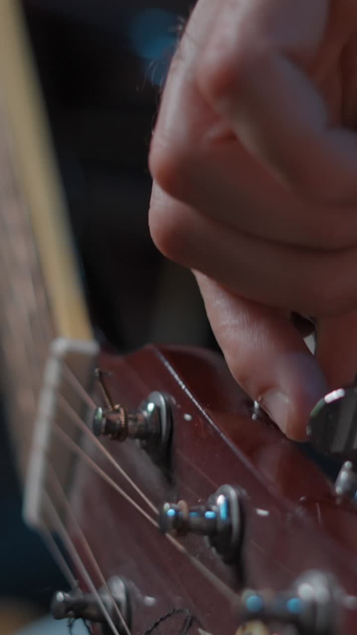 Close-up of Hand Tuning an Acoustic Guitar