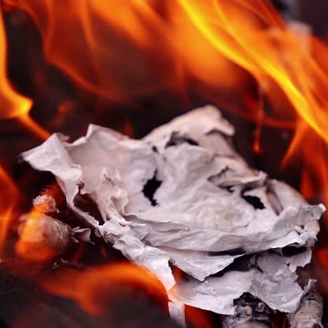 sheet of paper is burning in fire. bonfire with spurts of flame. power of fire. selective focus in video