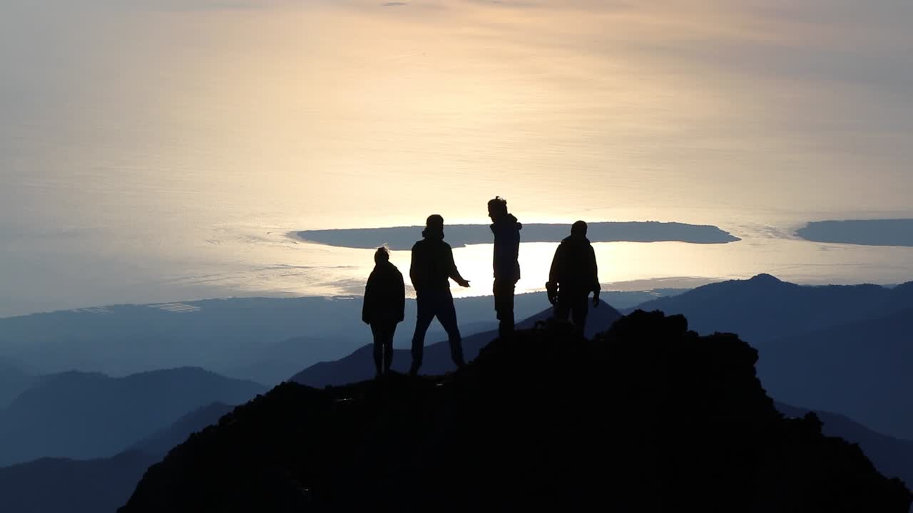산을 오른 후 경치를 감상하는 친구들의 실루엣