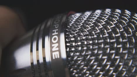 man switches on and holds microphone on blurred background