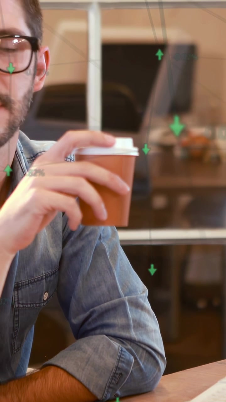 Video verticale: Lavoratore uomo che prende una tazza, sorseggiando mentre dati finanziari verdi fluttuano intorno alla tazza.