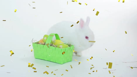 animation of confetti falling over basket of easter eggs and rabbit on white background