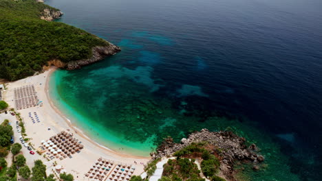 aerial drone shot of greek landscape with turquoise sea or ocean bay and empty sand beach