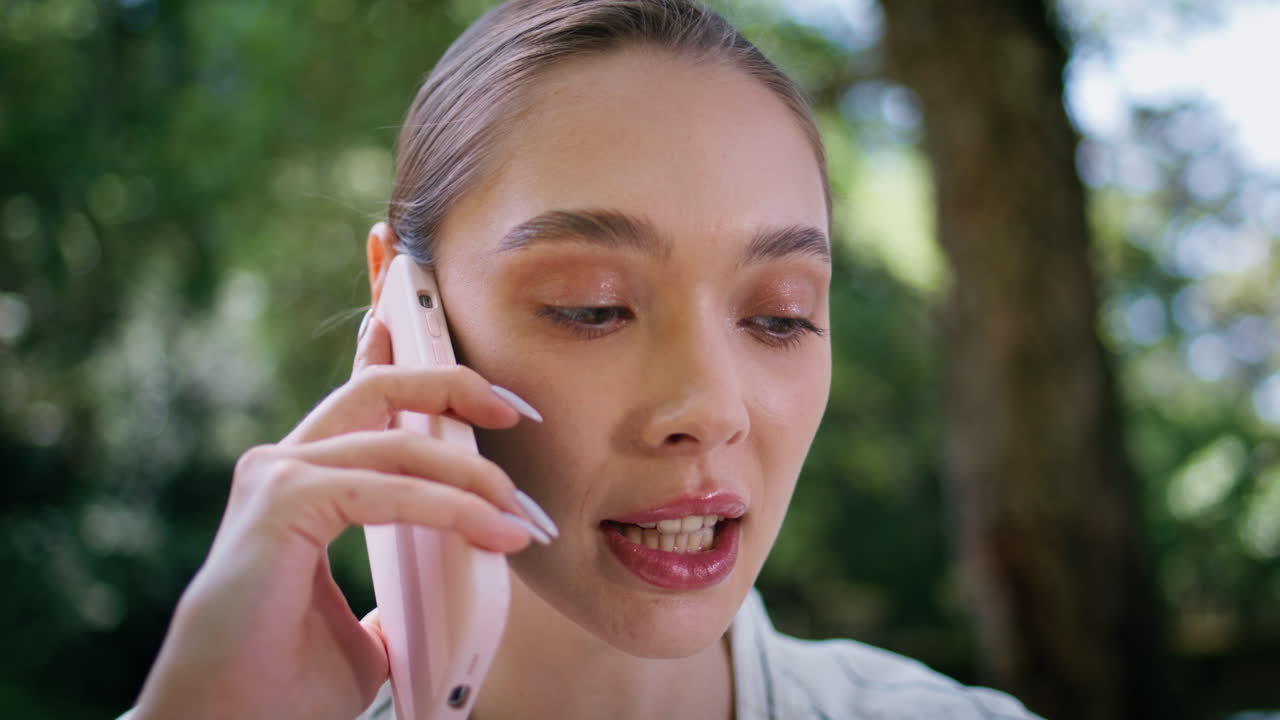 Closeup beautiful woman calling by mobile phone on nature. Serious lady speaking