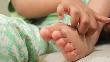 child scratching foot