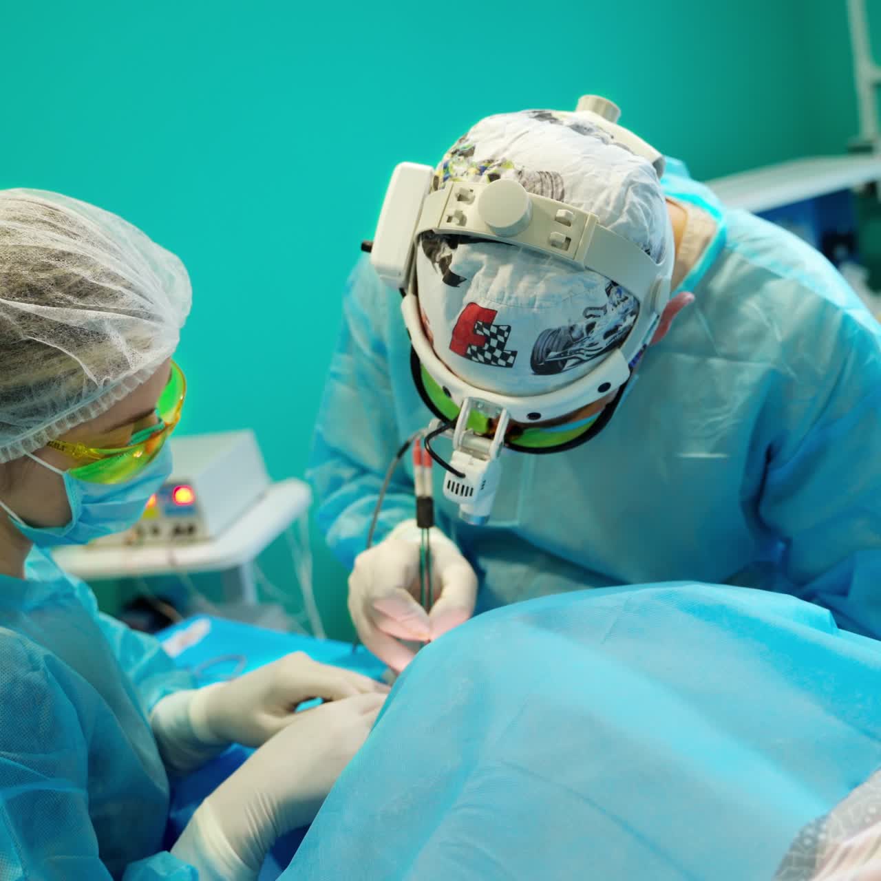 Two surgeons during surgery in the operating room. Professional doctor and a nurse in a modern hospital doing plastic surgery with special equipment.
