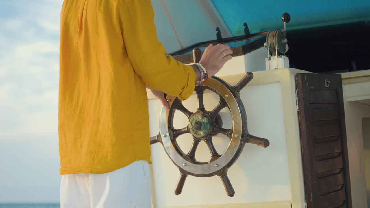 Primo piano di persone irriconoscibili che timonano una barca in una giornata di sole in mare, navigazione e stile di vita di svago.