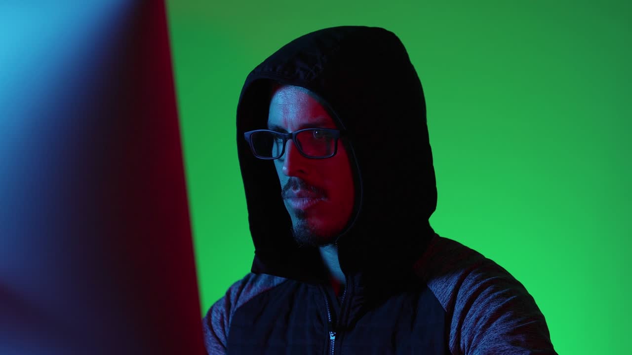 un hacker davanti a un monitor che lavora con un computer.