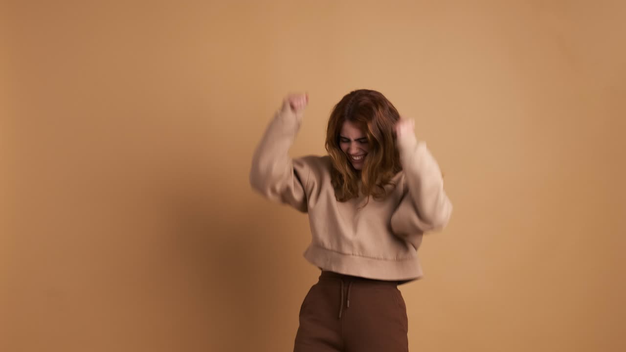 Smiling young woman jumping and waving hands