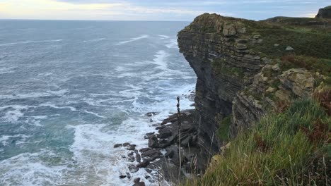 from the rocky edge of the cliff of the island of isla blue colored cantabrian sea can be seen