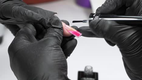 manicurist applying polishing on nail uhd