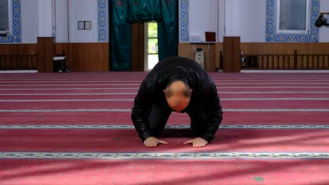 man kneels and prays in mosque 4