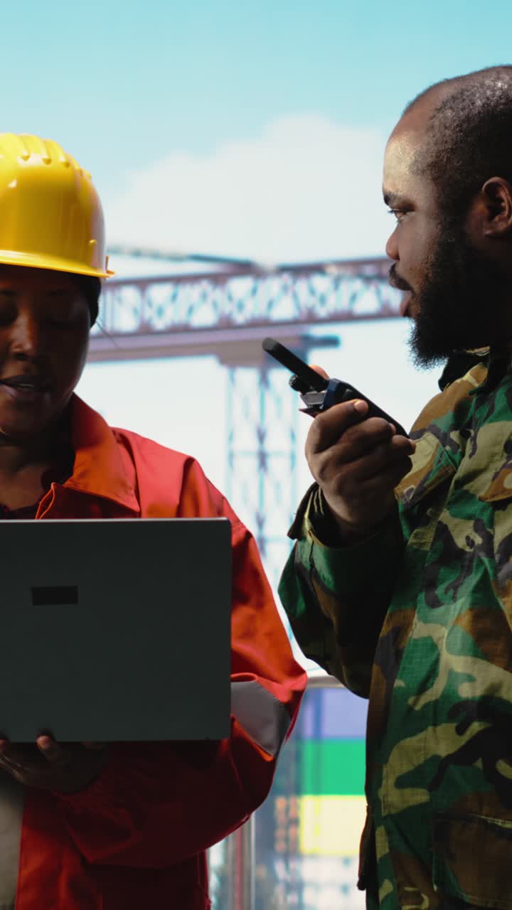Vertical video Soldier on offshore platform transmitting security report with walkie talkie