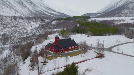 Red-church-in-a-dramatic-winter-landscape-in-Kåfjord,-Northern-Norway