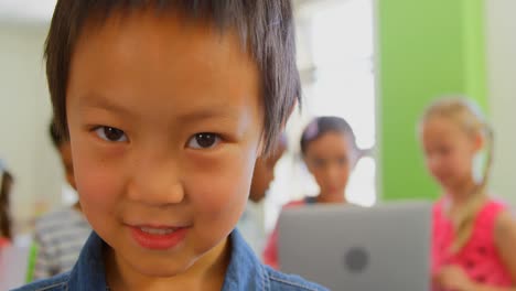 happy asian schoolboy standing in a classroom at school 4k