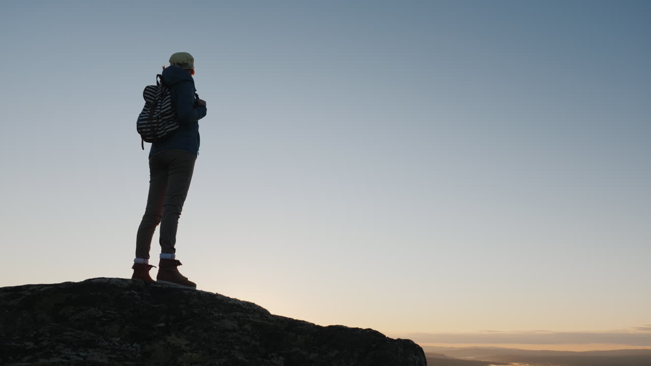 una mujer viajera se encuentra en la cima de una montaña mira el hermoso paisaje por delante admira la natu