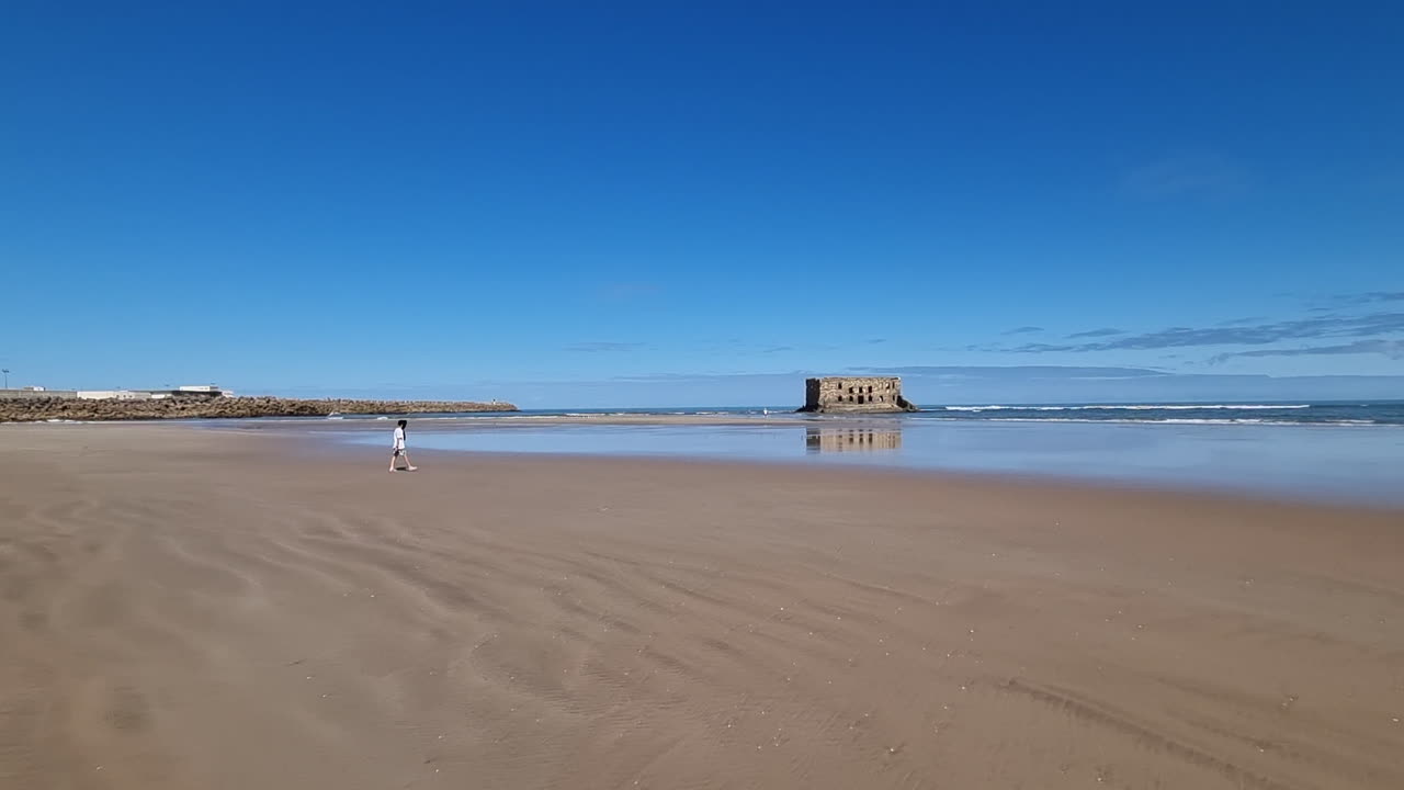 a person walks towards the beach in Casa del mar, Tarfaya,, Marroco. 4K videos. walk along the sandy beach