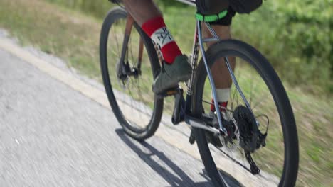 close up of man riding his bicycle on the road and spinning the bicycle chain