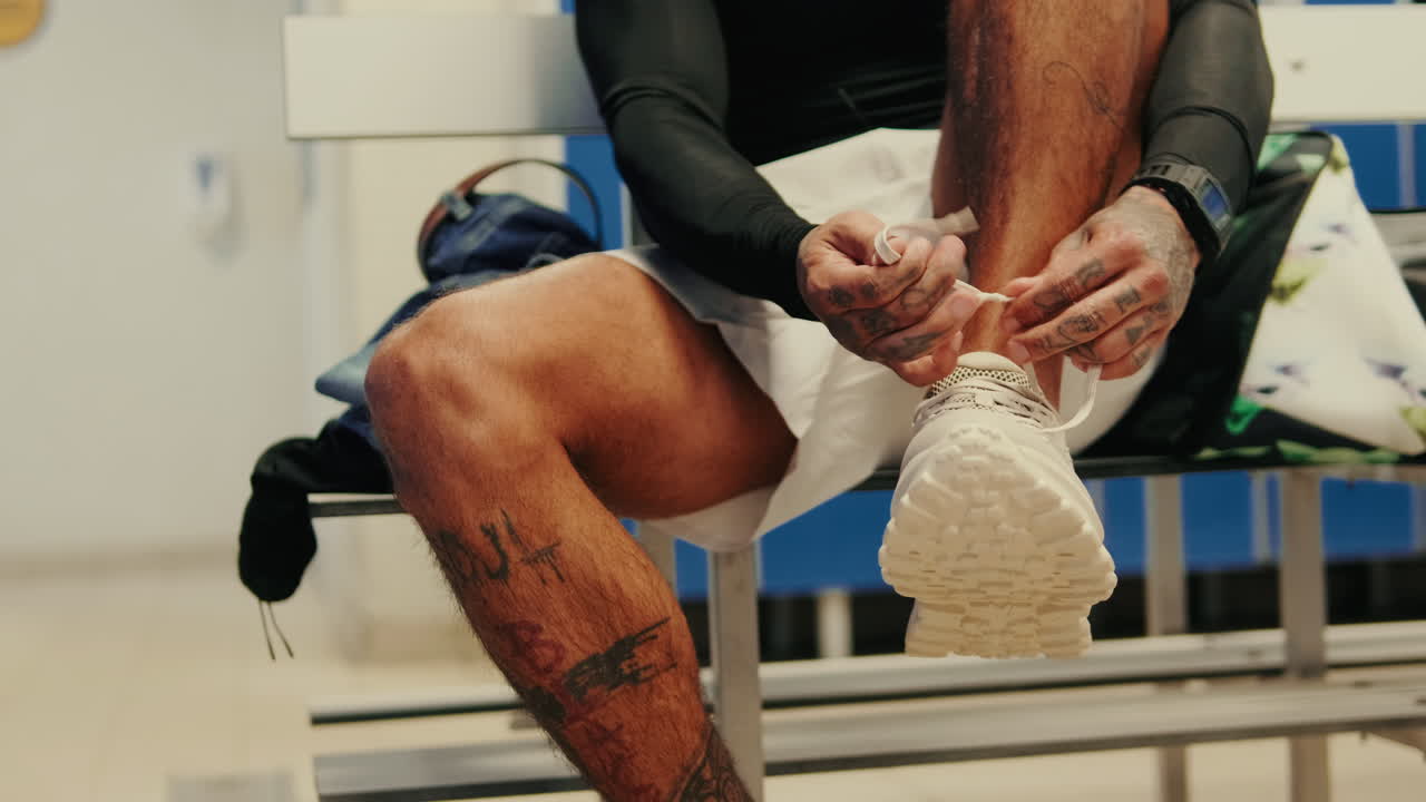 Uomo che si allaccia le scarpe nello spogliatoio prima dell'allenamento