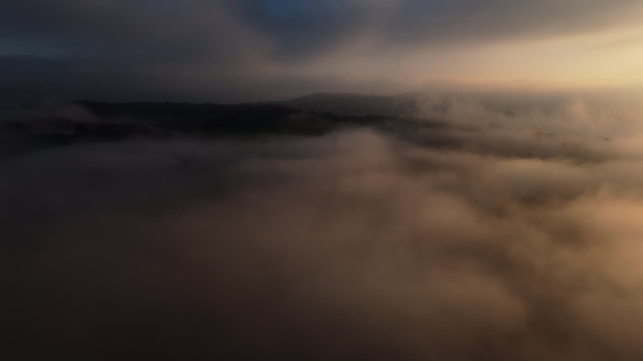 Drone captures breathtaking views above the clouds during sunset, showcasing vibrant sky colors and a peaceful atmosphere high above the landscape