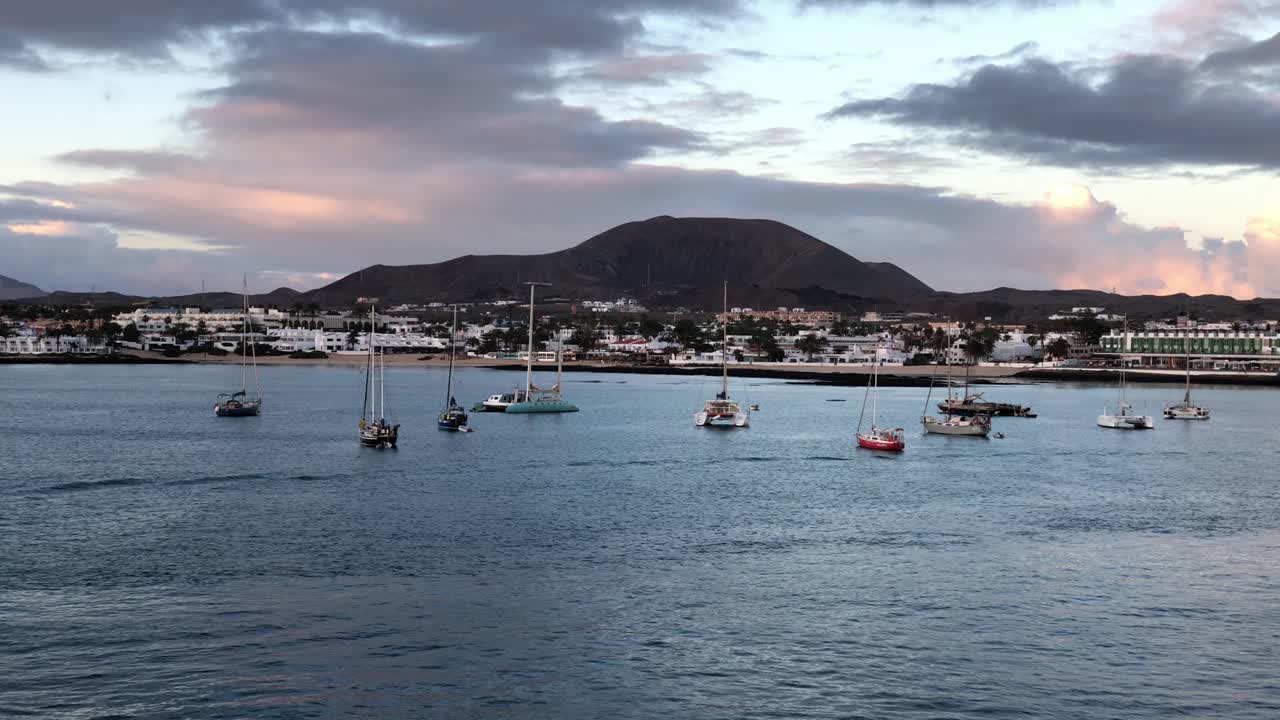 vista aérea del atardecer de la ciudad de corralejo en la costa noreste de fuerteventura, una de las islas canarias de españa atardecer dramático con un velero amarrado en la bahía
