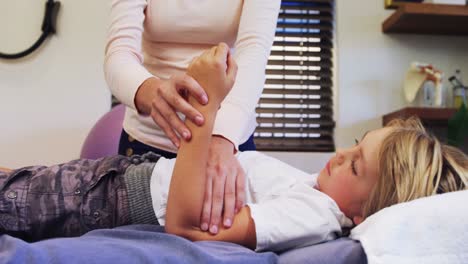 Female-physiotherapist-giving-hand-massage-to-boy-patient-4k