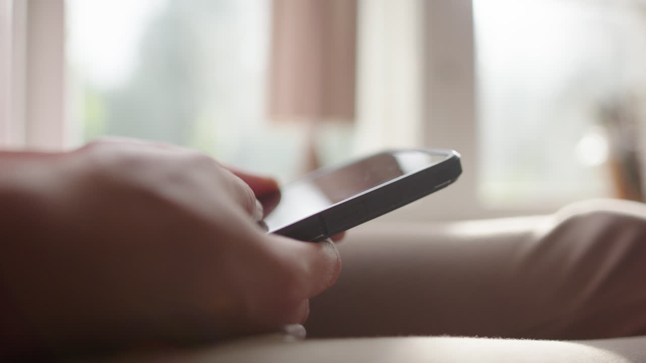 Mindless scrolling on smartphone, lots of screen time in tech age. Hand closeup