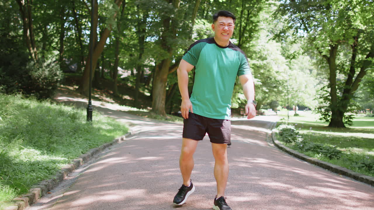 Japanese runner athlete man with muscle pain in park trauma injury while jogging leg muscle cramp