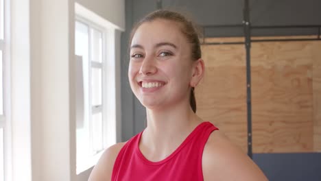 portrait of happy unaltered caucasian woman taking a break from cross training at gym, slow motion