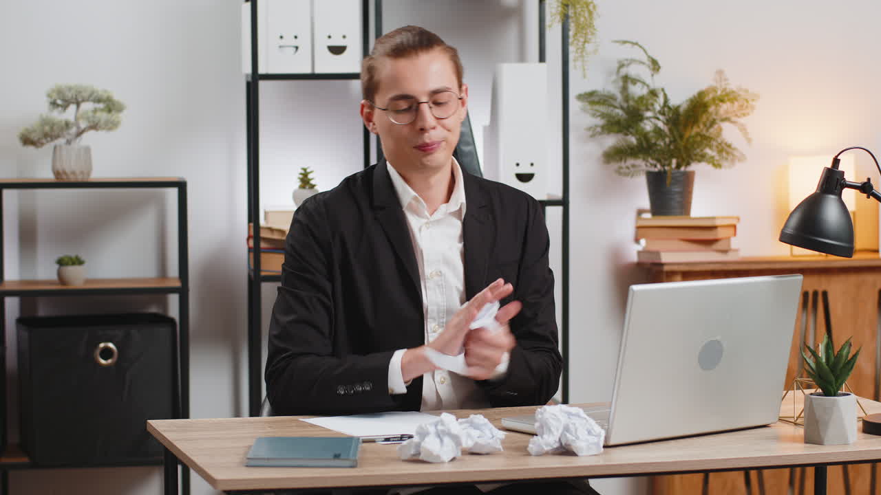 uomo d'affari che scrive a tavola con errore mancanza di ispirazione sgretola un foglio di carta e butta via