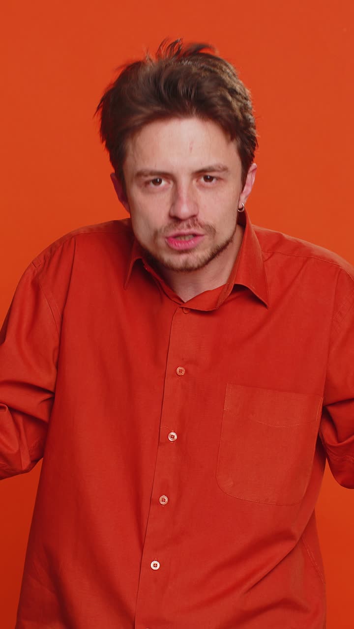 hombre caucásico tratando de oírte mirando confundido y fruncido el ceño manteniendo el brazo cerca de la oreja para una voz más alta