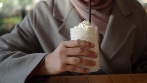 woman drinking a milkshake with whipped cream