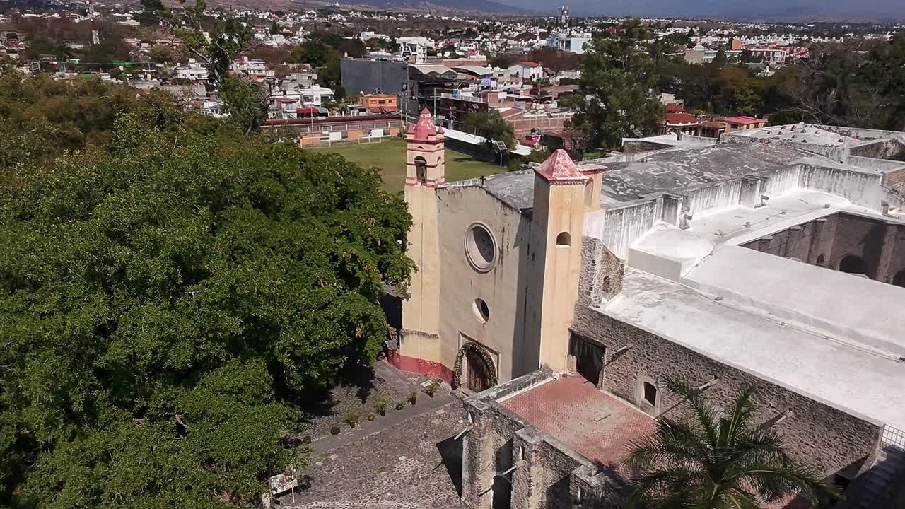 Old ruins surrounded by trees with a scenic view of the town in the background