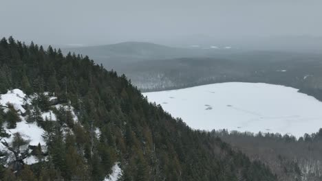 Evergreen-Forest-Mountains-Revealed-Frozen-Lake-In-Quebec,-Canada