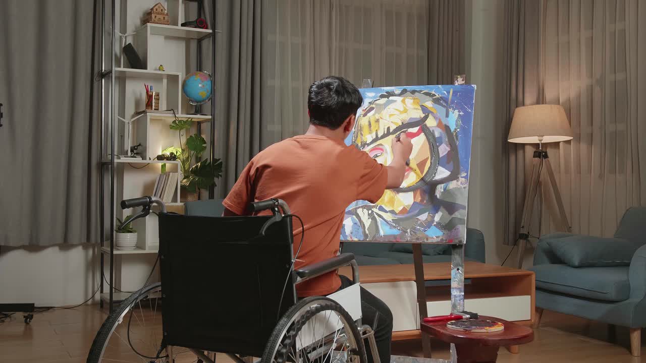 vista trasera de un niño artista asiático en silla de ruedas sosteniendo un pincel y pintando el rostro de una niña en el lienzo