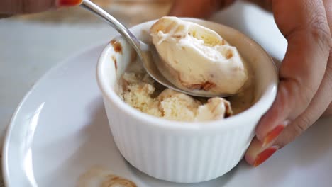 woman eating vanilla ice cream with chocolate sauce