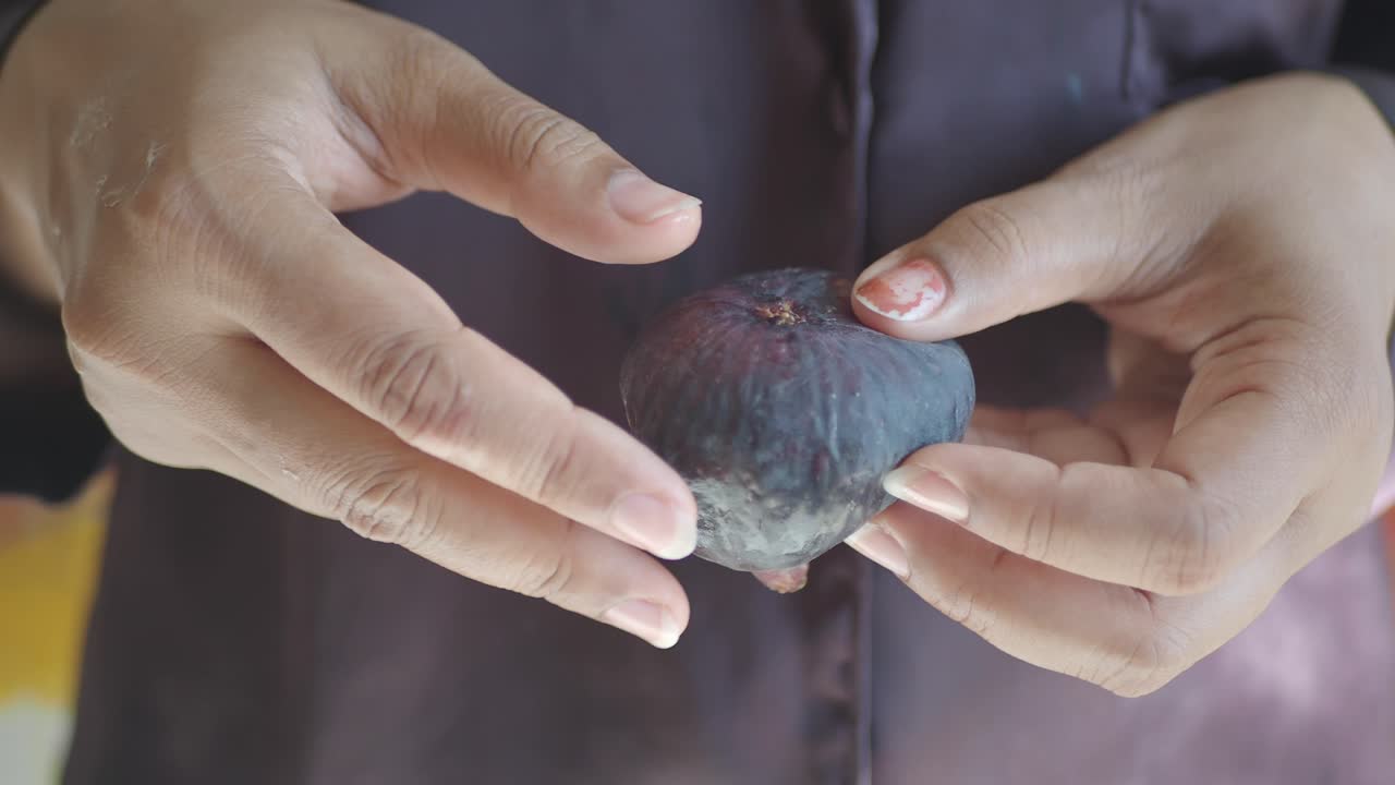 Hands Holding and Cutting Figs
