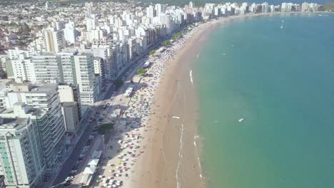 Tilting-aerial-shot-of-Praia-do-Morro,-Guarapari,-Espirito-Santo-on-Carnival