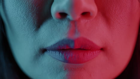 Close-up Portrait of Woman with Neon Lighting and Finger Over Lips