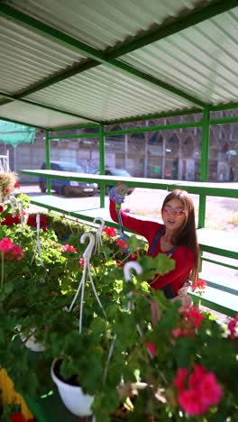 mujer regando plantas en un centro de jardín