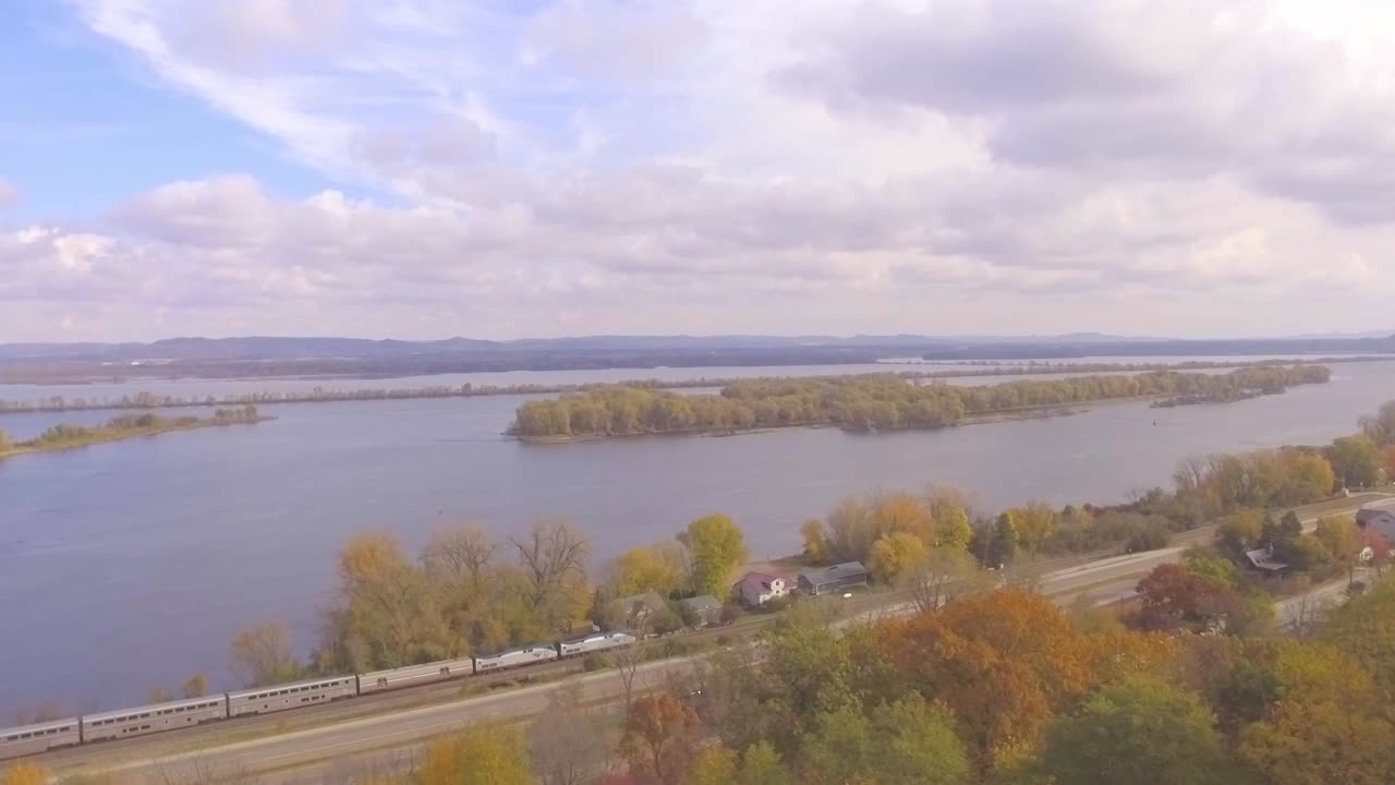 Et tog kører langs en motorvej om efteråret i Minnesota.