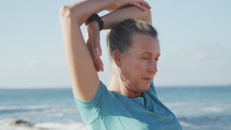 Senior-woman-stretching-her-arms-on-a-promenade