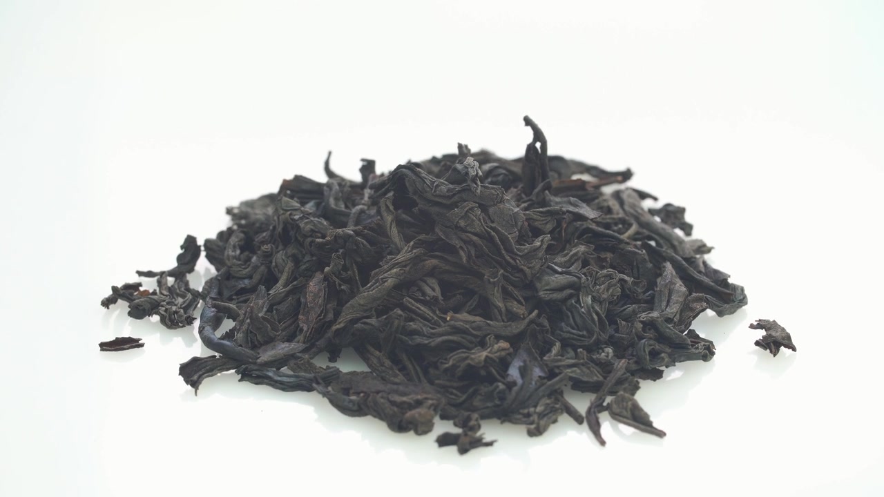 Pilha de Folhas de Chá Preto Secas em Fundo Branco