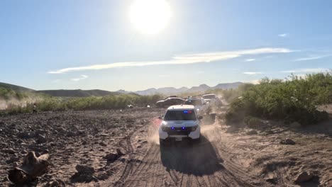 Cop-car-driving-on-a-dirty-road-with-blinking-emergency-police-lights