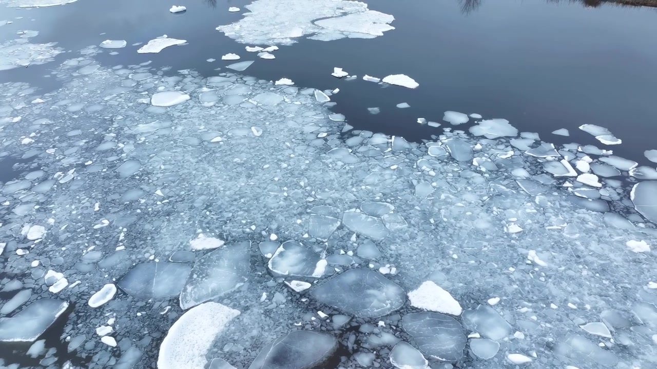 Témpano de hielo roto a la deriva en agua oscura, paleta azul frío con losas de hielo dispersas, aguas abiertas finas.