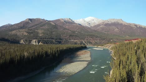 vista aérea del río alaska que se eleva para revelar montañas.