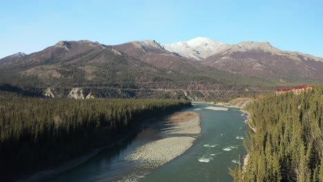 aerial view of alaskan river pans up to reveal mountains