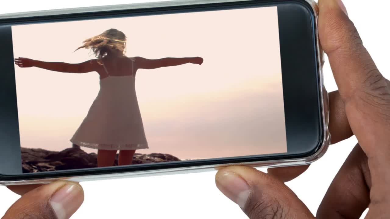 mano sosteniendo teléfono móvil con mujer bailando 4k