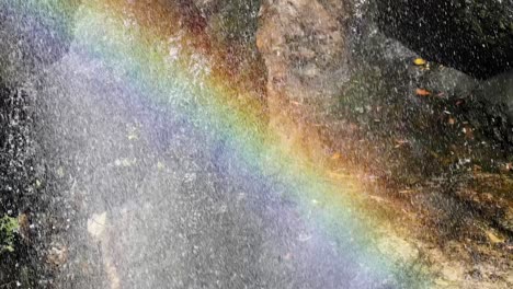 un arco iris vibrante se forma sobre una cascada en cascada