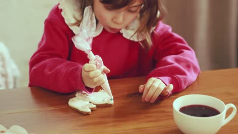 child decorating gingerbread cookies